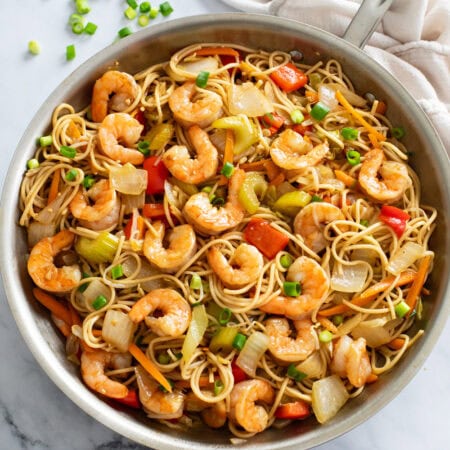 Shrimp Lo Mein with vegetables and sauce in a stainless steel skillet.