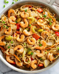 Shrimp Lo Mein in a skillet with sauce, vegetables, shrimp, and Lo Mein noodles.