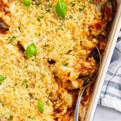 Eggplant Casserole in a baking dish with a spoon on the side.