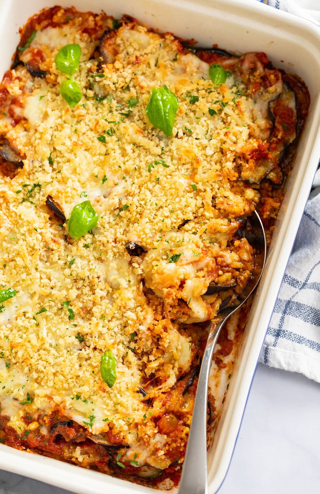 Eggplant Casserole in a baking dish with a spoon on the side.