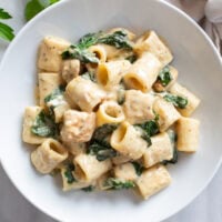 Chicken Spinach Pasta in a creamy sauce with chicken and spinach in a white bowl.