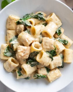 Chicken Spinach Pasta in a creamy sauce with chicken and spinach in a white bowl.