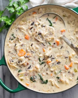 Chicken and Wild Rice Soup in a soup pot with a ladle. scooping it up.