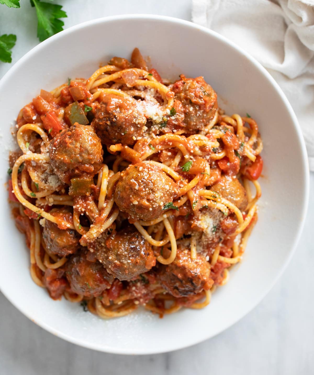 Sausage Spaghetti in a white bowl with balls of sausage, marinara sauce, and spaghetti.