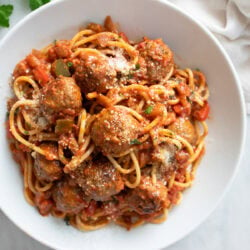 Sausage Spaghetti in a white bowl with sausage, marinara sauce, and spaghetti.