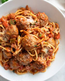 Sausage Spaghetti in a white bowl with sausage, marinara sauce, and spaghetti.