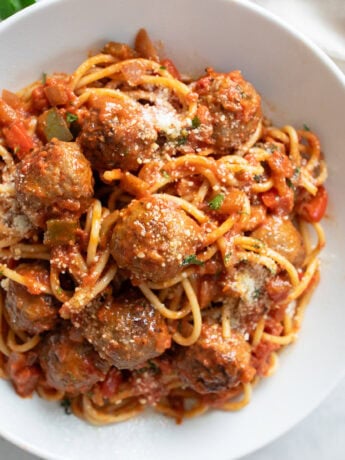 Sausage Spaghetti in a white bowl with sausage, marinara sauce, and spaghetti.