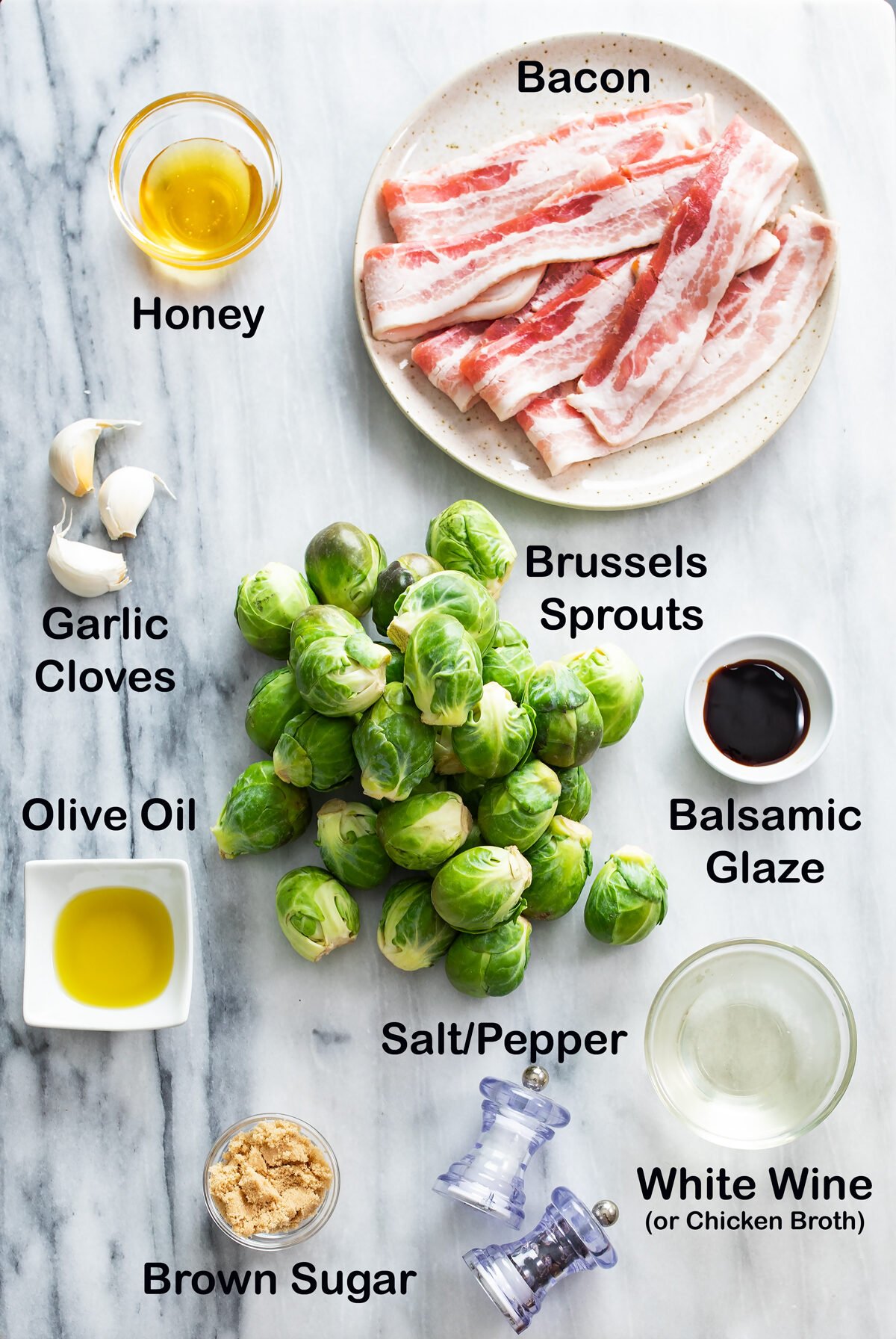 Overhead view of Ingredients for Bacon Brussels Sprouts on a white marble surface.