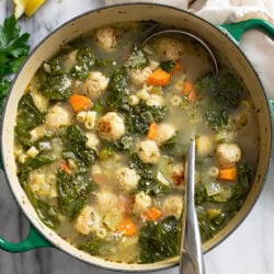 Chicken Meatball Soup with spinach, chicken meatballs, and pasta with a ladle on the side.