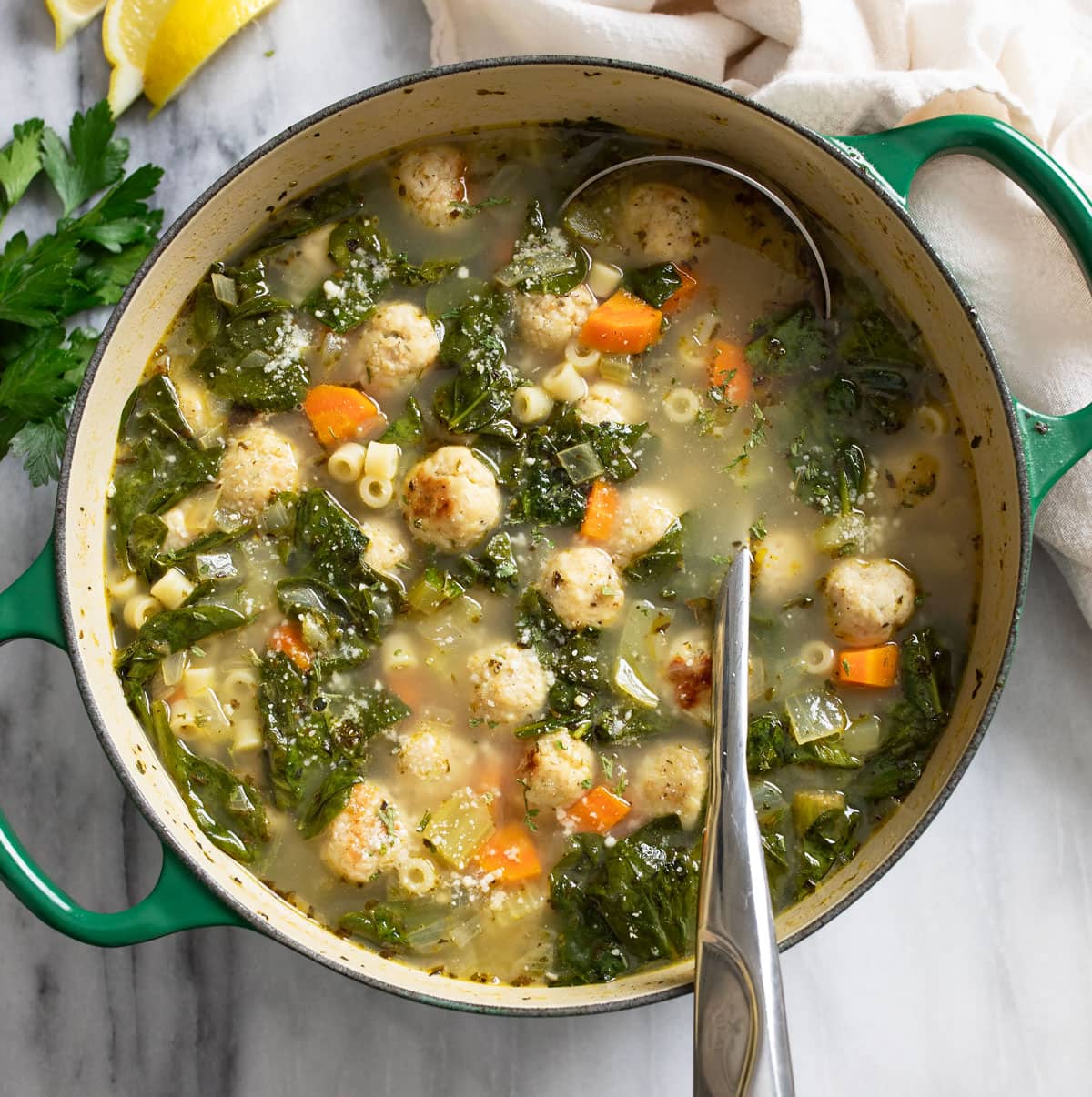 Chicken Meatball Soup in a pot with a ladle on the side.