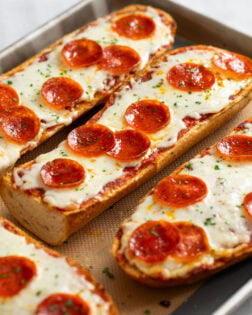 French Bread Pizza on a baking sheet topped with melted mozzarella and pepperoni.