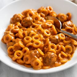 Homemade Spaghettios with mini meatballs in a white bowl.