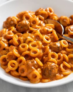 Homemade Spaghettios with mini meatballs in a white bowl.