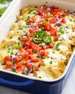 White Chicken Enchiladas with a creamy white sauce, cheese, and colorful toppings.
