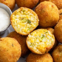 Fried Rice Balls on a plate with one sliced open to show the cheesy broccoli cheese filling.