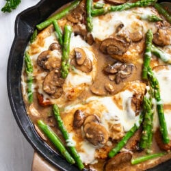 Chicken Madeira with mushrooms, melted mozzarella cheese, and asparagus.