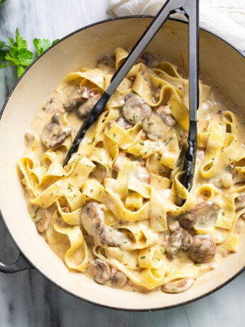 Truffle Pasta in a skillet with mushrooms and pappardelle tossed with a creamy Parmesan sauce.
