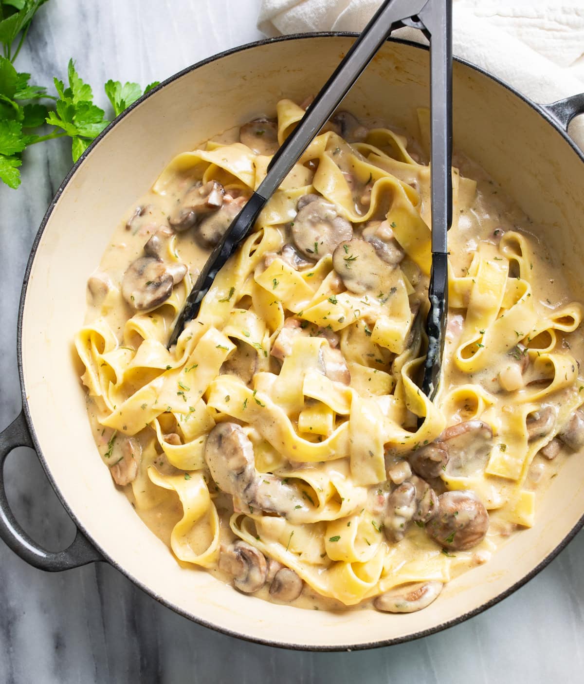 Truffle Pasta in a skillet with mushrooms and pappardelle tossed with a creamy Parmesan sauce.