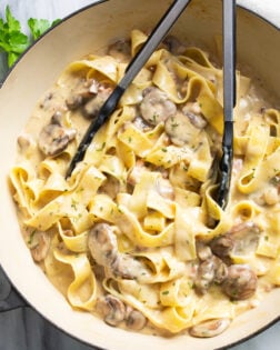 Truffle Pasta with a creamy mushrooms sauce and pappardelle pasta in a skillet with tongs on the side.