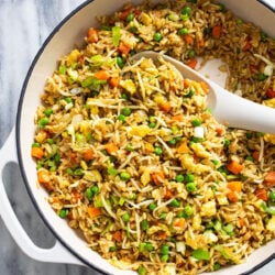 Vegetable Fried Rice in a white pot with a serving spoon on the side.
