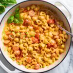 A white skillet filled with Cherry Tomato Pasta in a tomato cream sauce with herbs.