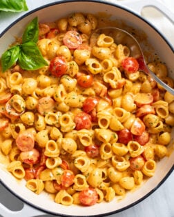 A white skillet filled with Cherry Tomato Pasta in a tomato cream sauce with herbs.