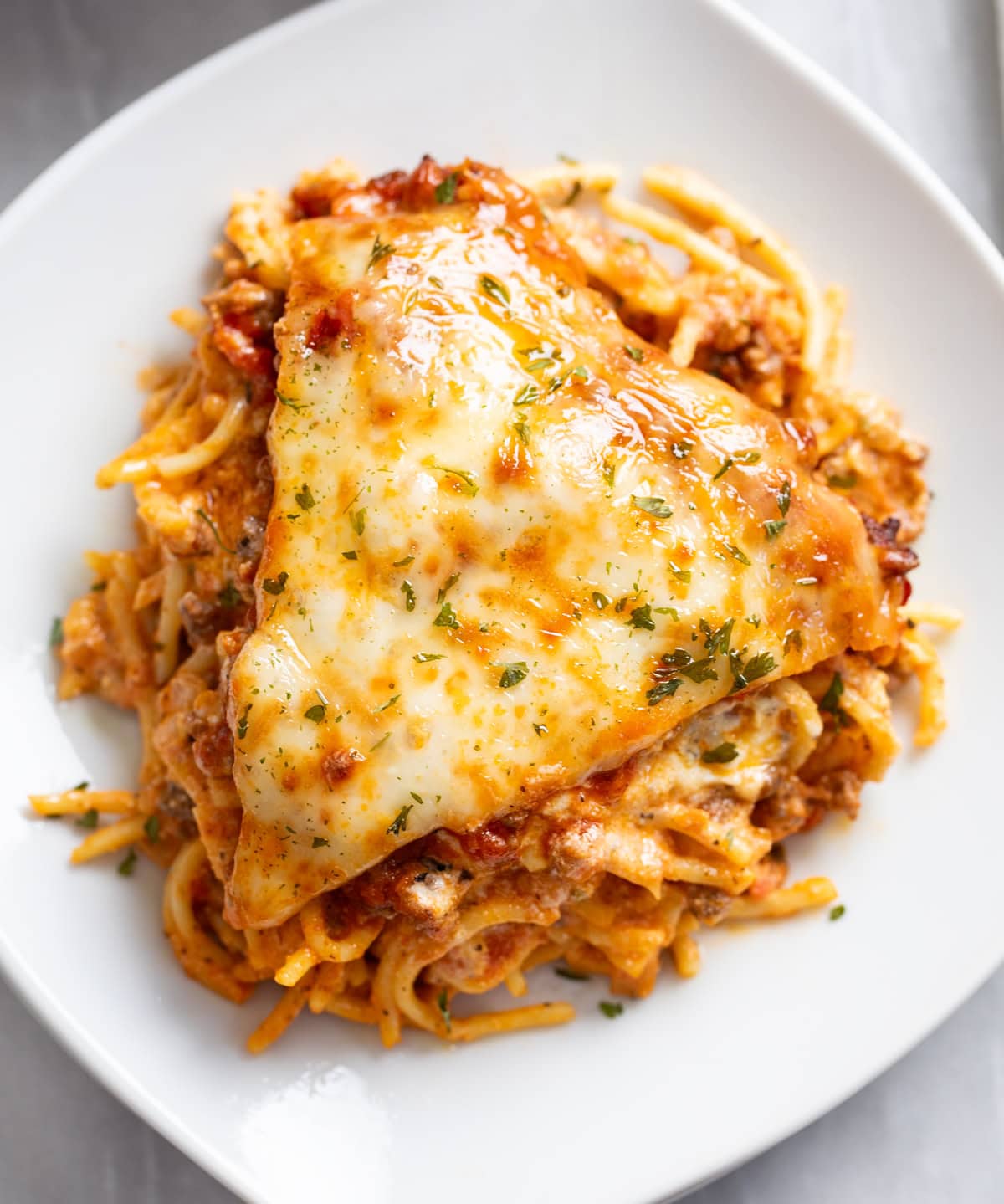 Overhead view of a slice of Spaghetti Pie on a white plate.