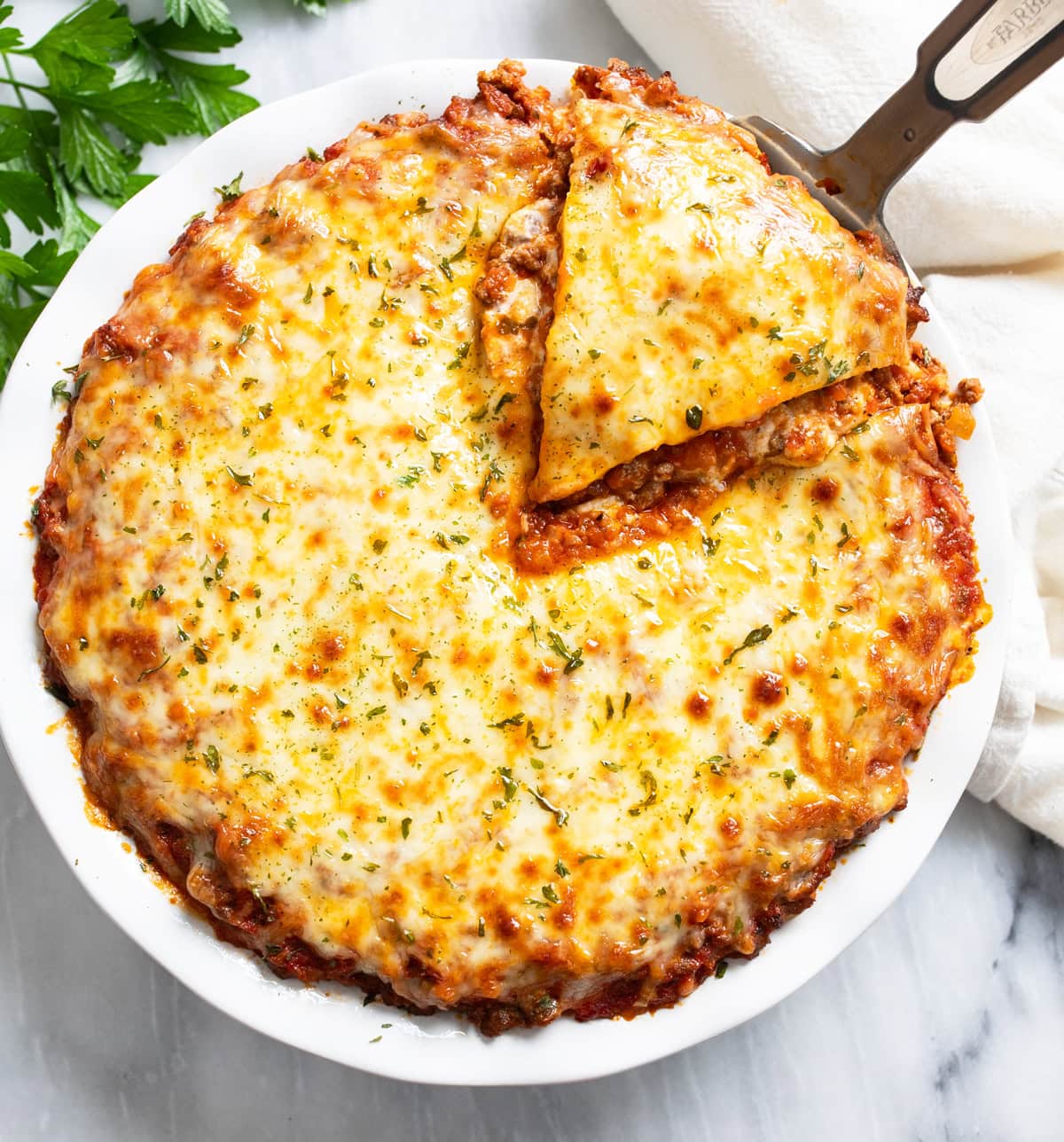 Overhead view of Spaghetti Pie in a baking dish with a slice being pulled out.