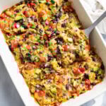Chicken Enchilada Casserole in a baking dish with a spatula lifting out a slice.