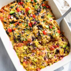 Chicken Enchilada Casserole in a baking dish with a spatula lifting out a slice.