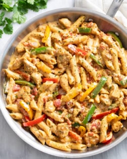 Overhead view of Chicken Fajita Pasta in a skillet with penne pasta in a creamy sauce with chicken and bell peppers.