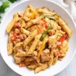 Chicken Fajita Pasta in w white bowl with bell peppers, chicken, penne, and a creamy sauce.