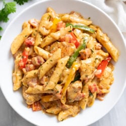 Chicken Fajita Pasta in w white bowl with bell peppers, chicken, penne, and a creamy sauce.