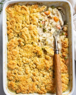 Chicken Pot Pie Casserole in a white casserole dish with a serving spoon on the side.