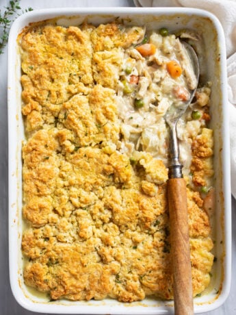 Chicken Pot Pie Casserole in a white casserole dish with a serving spoon on the side.