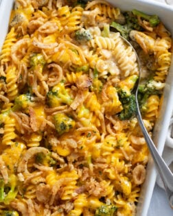 A Chicken and Broccoli Pasta Bake in a casserole dish with a spoon on the side.