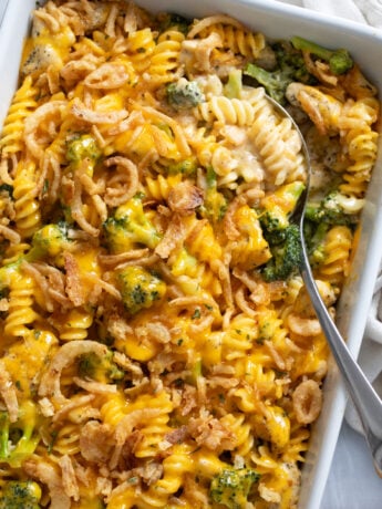 A Chicken and Broccoli Pasta Bake in a casserole dish with a spoon on the side.