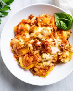 Ravioli Lasagna in a white bowl with fresh basil on the side.