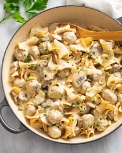 A skillet filled with Meatball Stroganoff in a creamy sauce with egg noodles and mushrooms.