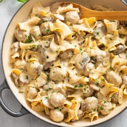 Meatball Stroganoff in a skillet with a wooden spoon on the side.