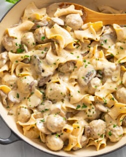 Meatball Stroganoff in a skillet with a wooden spoon on the side.