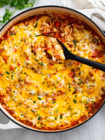 Unstuffed Peppers in a skillet with a spoon scooping it up.