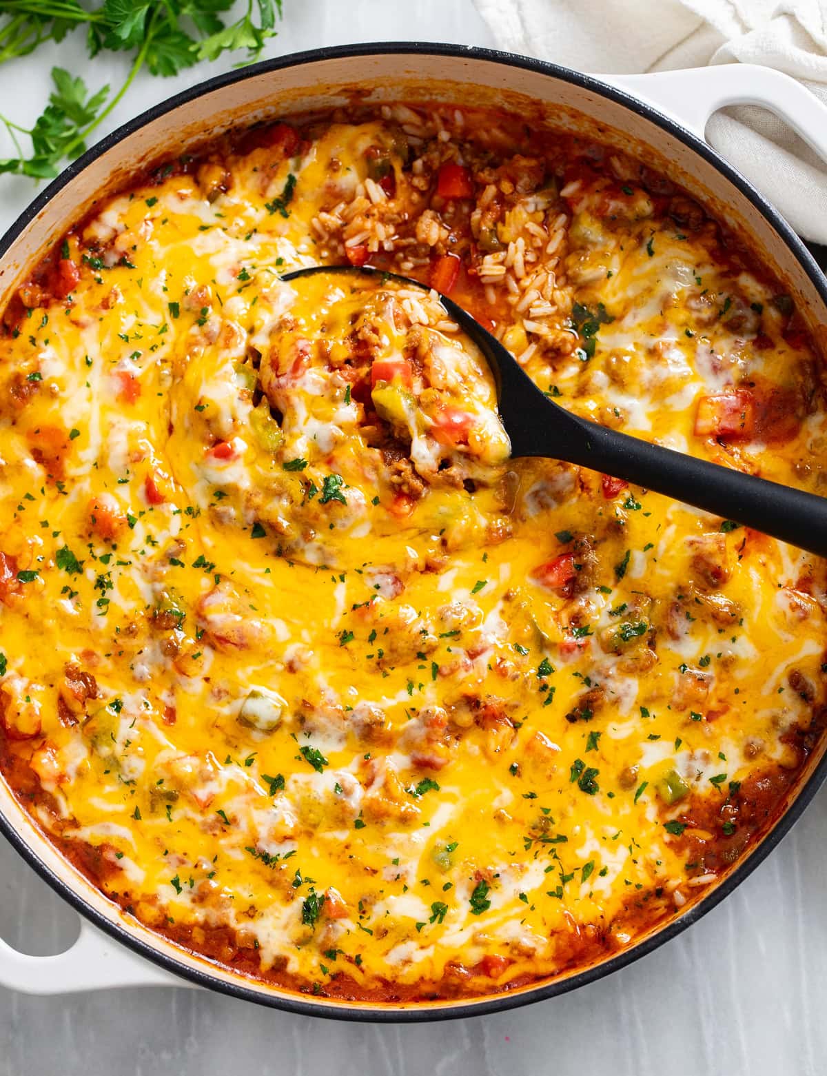 Unstuffed Peppers in a skillet with a spoon scooping it up.