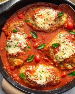 Chicken Pomodoro in a skillet with a homemade tomato sauce and fresh basil on top.