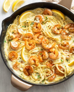 Lemon Shrimp Pasta in a skillet with lemon wedges and parsley.