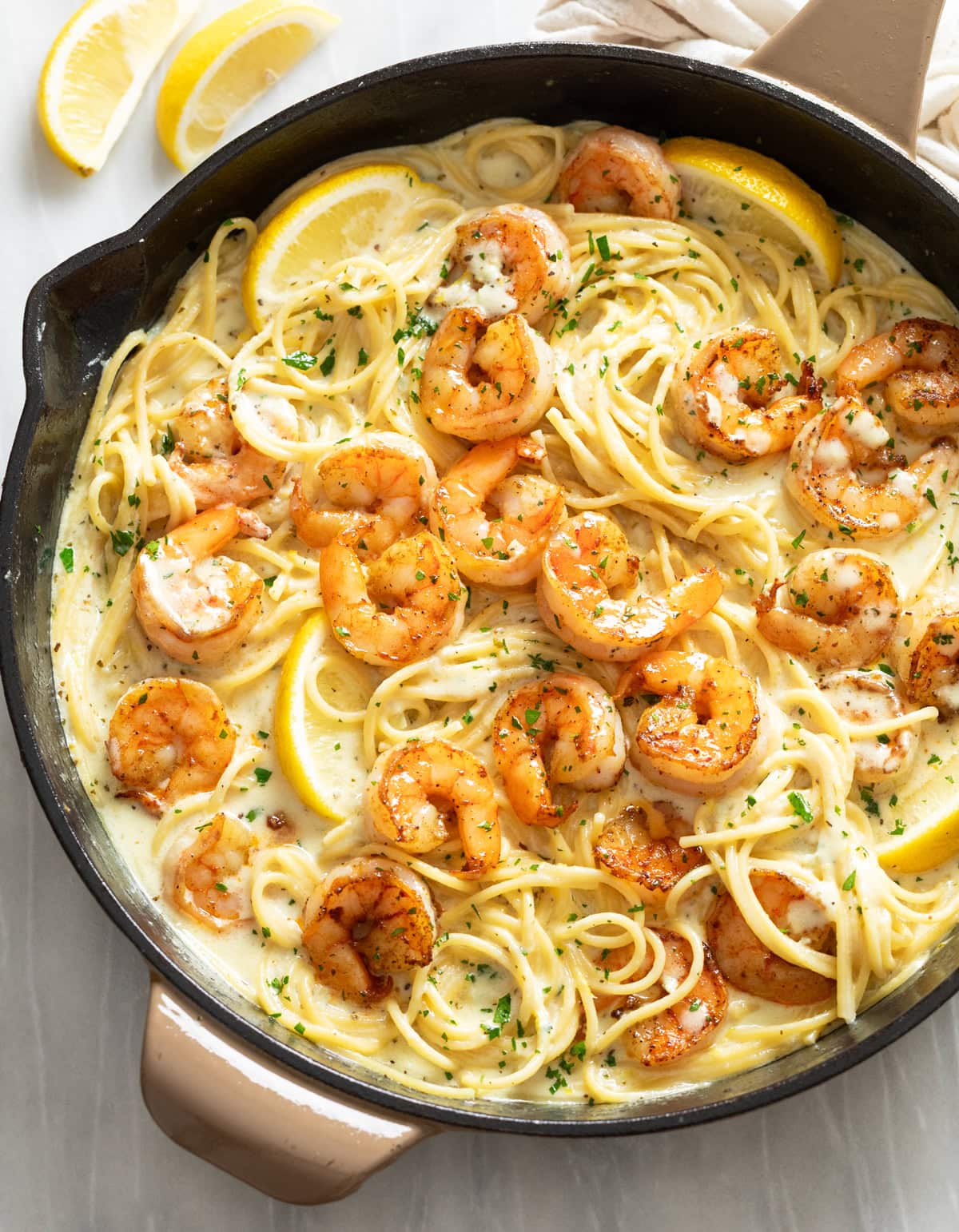 Lemon Shrimp Pasta in a skillet with lemon wedges and parsley.