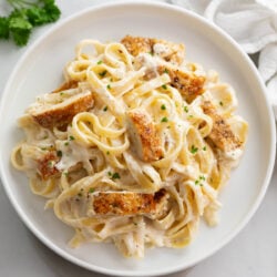 Overhead view of Chicken Alfredo Pasta with sliced, golden-brown chicken breast and fettuccine coated in a creamy homemade Alfredo sauce.