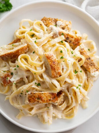 Overhead view of Chicken Alfredo Pasta with sliced, golden-brown chicken breast and fettuccine coated in a creamy homemade Alfredo sauce.